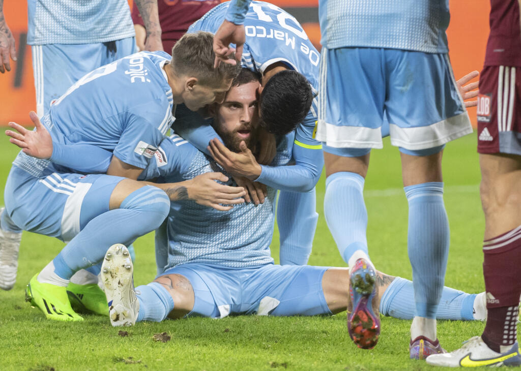 Na snímke uprostred strelec gólu na 2:1 z 88. minúty Guram Kašia zo Slovana v objatí spoluhráčov, vľavo Ivan Šaponjič a vpravo Vernon De Marco v zápase 12. kola futbalovej Fortuna ligy medzi ŠK Slovan Bratislava - FK Železiarne Podbrezová 2. októbra 2022 v Bratislave.