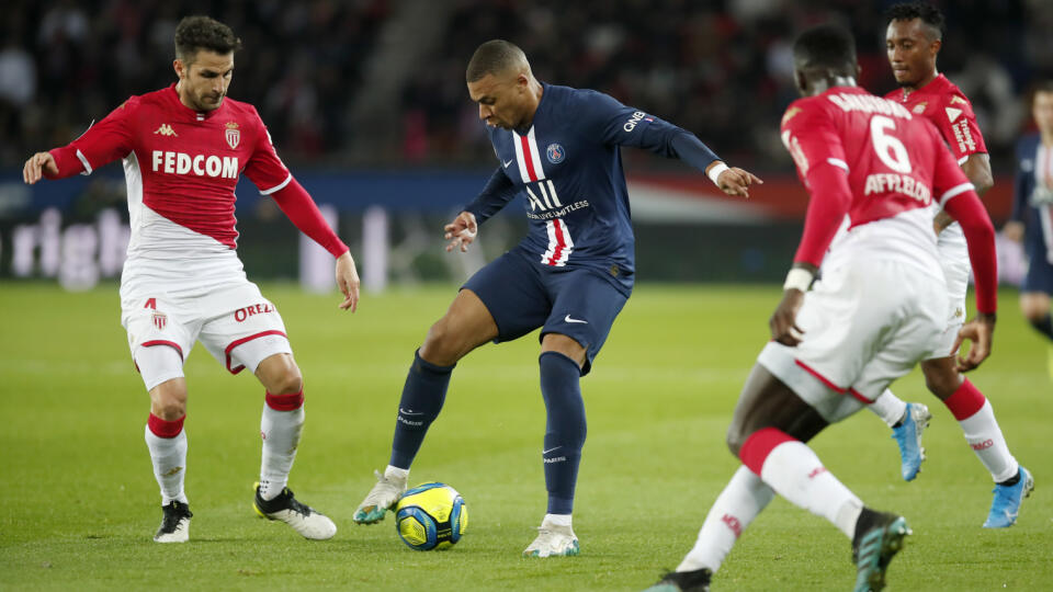 Hráč PSG Kylian Mbappé (uprostred) v súboji s Tiemoueom Bakayokom (vpravo) a Cescom Fabregasom (vľavo) z Monaka.
