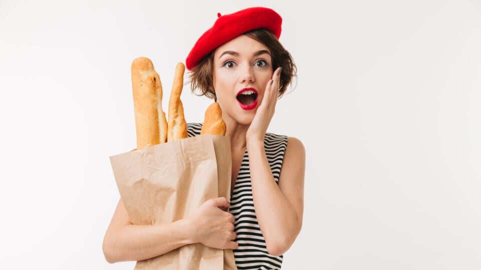 Portrait,Of,A,Surprised,Woman,Wearing,Beret,Holding,Paper,Bag