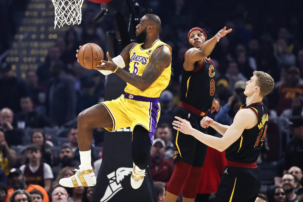 JB 1 Cleveland - Hráč Los Angeles Lakers LeBron James (vľavo hore) strieľa na kôš cez Lamara Stevensa (8) a Lauriho Markkanena (24) z Clevelandu Cavaliers v basketbalovom zápase zámorskej NBA v Clevelande 21. marca 2022. FOTO TASR/AP
Los Angeles Lakers' LeBron James (6) shoots against Cleveland Cavaliers' Lamar Stevens (8) and Lauri Markkanen (24) during the first half of an NBA basketball game, Monday, March 21, 2022, in Cleveland. (AP Photo/Ron Schwane)