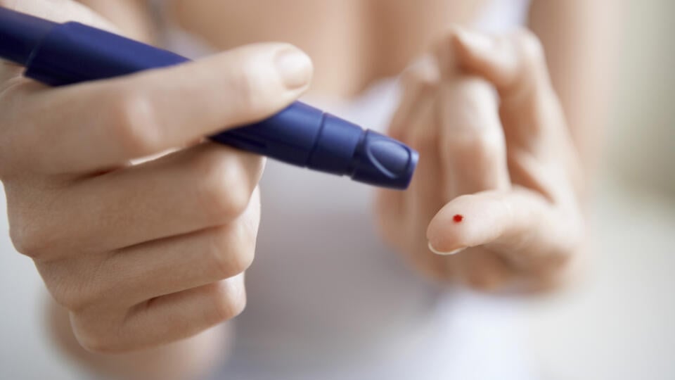 Midsection,Of,Woman,Using,Lancelet,On,Finger