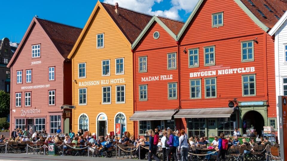 Bergen, Norway - July 9, 2024: Tourists at outdoor cafes in front of Bryggen wooden buildings