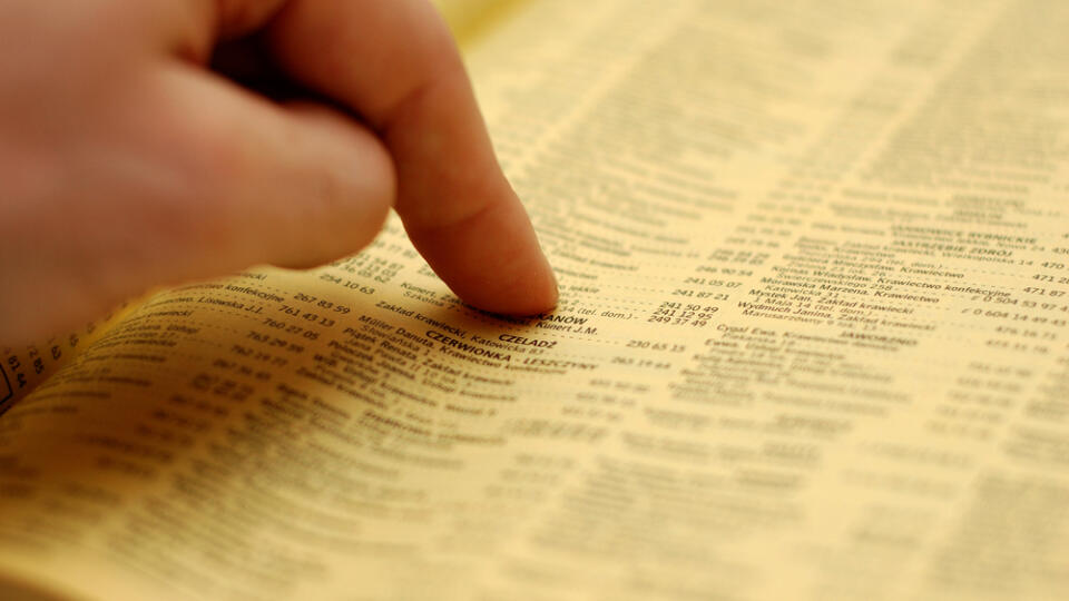 Hand,Pointing,An,Advertisement,In,A,Phone,Book