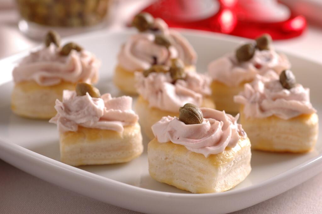Zamilovane chutovky
Suroviny: 1 lístkové cesto, 1 vajce, 100 g tvarohového syra, 50 g taveného syra, 50 g rastlinného margarínu, 1 lyžica zaváraných brusníc, štipka soli
Na ozdobu: zelené a čierne olivy, kapary
Pracovný postup:
Lístkové cesto vyvaľkáme na hrúbku približne 3 mm a povykrajujeme srdiečka. Potrieme ich rozšľahaným vajcom a vo vyhriatej rúre upečieme. Do hladka vymiešame tvarohový a tavený syr, pridáme maslo, brusnice a podľa chuti štipku soli. Syrový krém dáme do cukrárskeho vrec