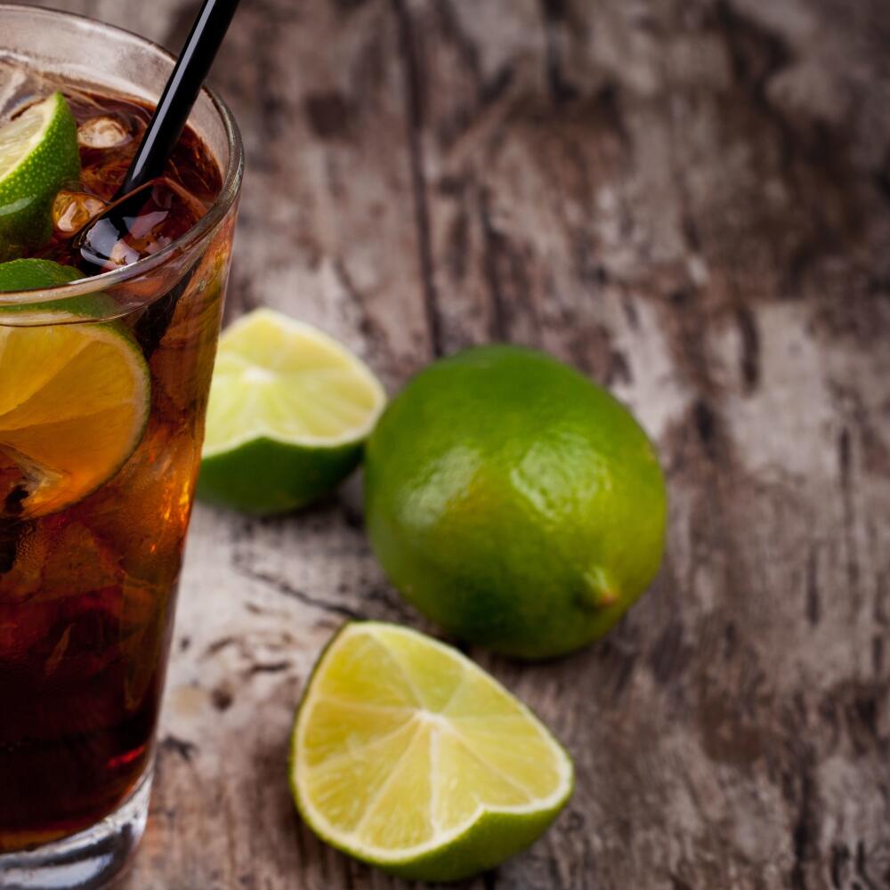 Cuba Libre Drink with lime on a wooden table
