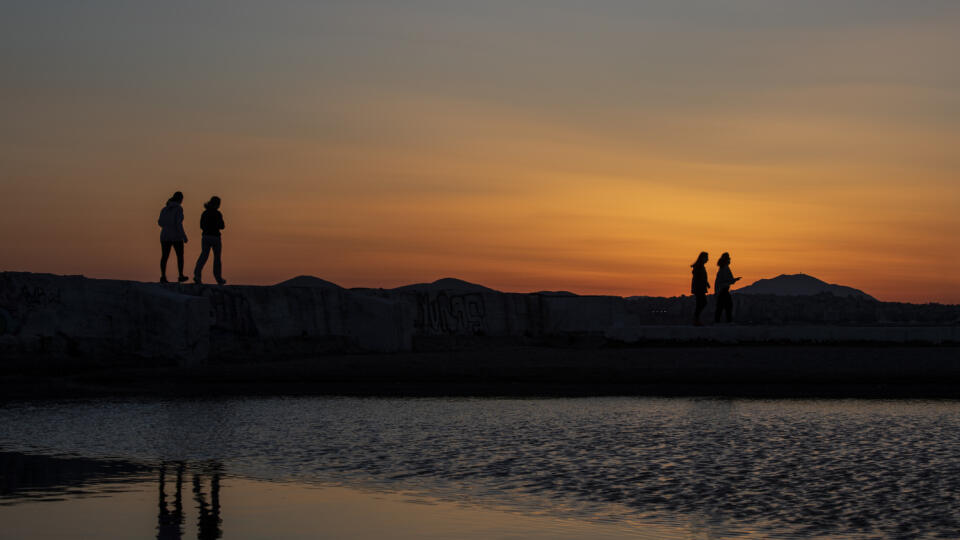 KK78 Atény - Chodci kráčajú pozdĺž prístavu počas západu slnka na predmestí Alimos pri Aténach v piatok 9. apríla 2021. FOTO TASR/AP
Pedestrians walk along a harbour during sunset in Alimos, a seaside suburb of Athens, on Friday, April 9, 2021. (AP Photo/Petros Giannakouris)