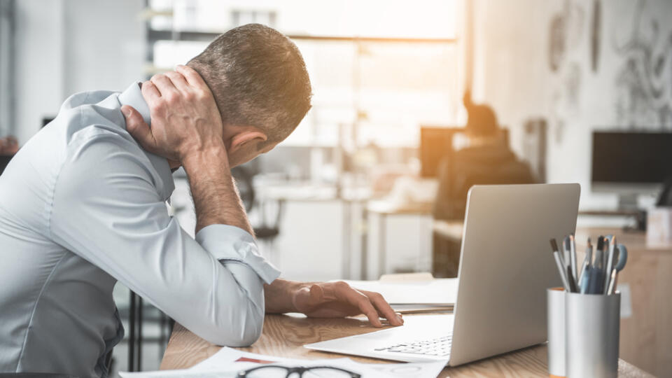 Man,Holding,Sore,Neck,While,Using,Notebook,Computer.,He,Sitting