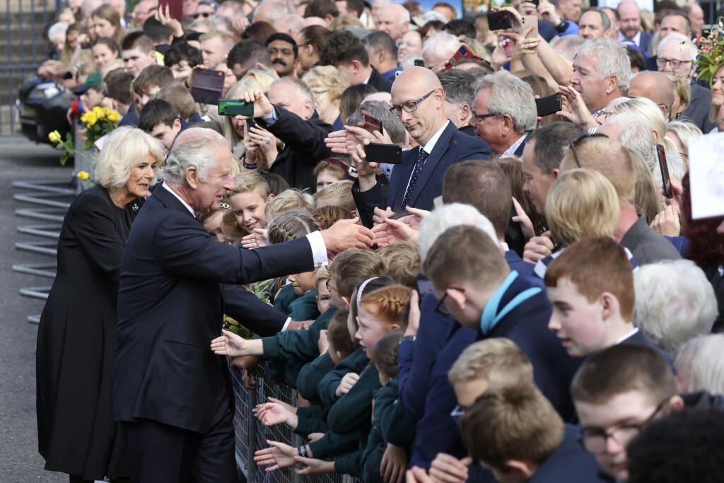Britský kráľ Karol III. (druhý zľava) a Camilla, kráľovná manželka (vľavo) sa zdravia s ľuďmi pred zámkom Hillsborough počas ich návštevy v severoírskom Belfaste 13. septembra 2022.