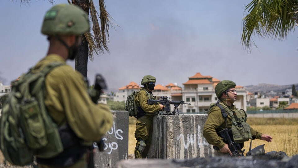 JB 10 Turmus Ayya - Des soldats israéliens patrouillent à l'entrée de la ville palestinienne de Turmus Ayya en Cisjordanie le 21 juin 2024. Des colons israéliens ont incendié des voitures palestiniennes après que des tireurs d'élite palestiniens ont tué quatre Israéliens dans le nord de la Cisjordanie mardi.  Depuis mercredi matin, les forces de sécurité israéliennes se préparent à démolir les maisons de deux militants palestiniens liés au groupe terroriste Hamas, qui ont commis mardi une attaque près d'une colonie juive en Cisjordanie.