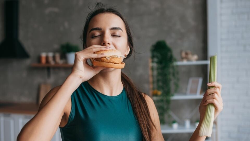 Fit,Woman,In,Sportwear,Eating,Burger,In,The,Kitchen,After