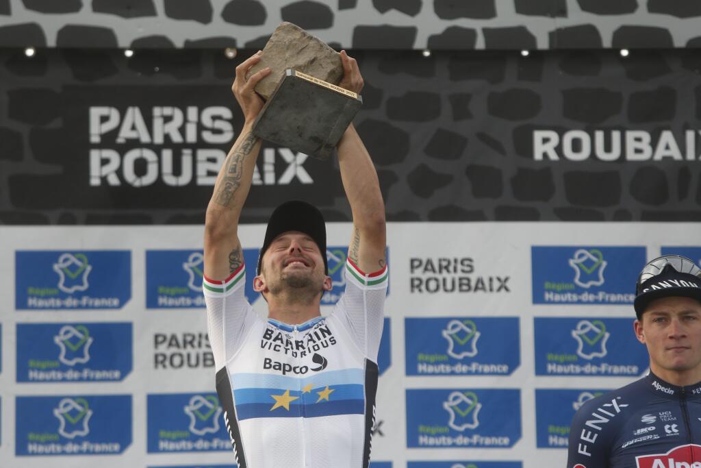 Taliansky cyklista Sonny Colbrelli zdvíha trofej po jeho víťazstve pretekov 118. ročníka monumentu Paríž - Roubaix vo francúzskom meste Roubaix 3. októbra 2021.