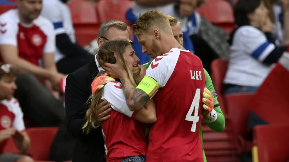 WA 53 Kodaň - Brankár dánskej futbalovej reprezentácie Kasper Schmeichel (zelený dres) a kapitán Simon Kjaer utešujú Sabrinu Kvistovú (druhá vľavo), manželku dánskeho futbalistu Christiana Eriksena, ktorý skolaboval počas zápasu základnej B-skupiny Dánsko - Fínsko na európskom šampionáte v Kodani v sobotu 12. júna 2021. FOTO TASR/AP
Denmark's team captain Simon Kjaer right, talks to a woman wearing a team jersey of Denmark's Christian Eriksen who was taken away from the field on a stretcher af