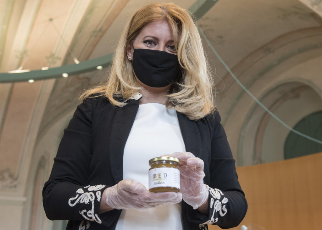 Na snímke prezidentka SR Zuzana Čaputová pózuje s pohárom medu počas prvého stáčania medu z úľov umiestnených v Prezidentskej záhrade v rámci spoločného projektu Kancelárie prezidenta SR a Centra environmentálnej a etickej výchovy Živica Mestské včely 4. septembra 2020 v Bratislave. FOTO TASR - Martin Baumann