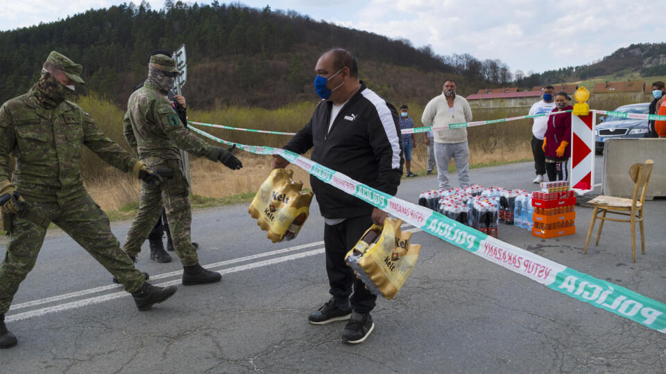 Rómom zo sídliska Dreveník, časť obce Žehra (okres Spišská Nová Ves), ktorá je v karanténe kvôli výskytu nového typu koronavírusu, doniesli nápoje. Na príkaz hliadky polície a armády, ktorá stráži priestor v karanténe, museli Rómovia vrátiť späť alkoholické pivá. Žehra 17. apríla 2020. FOTO TASR - Milan Kapusta

