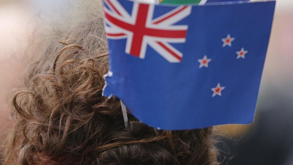 FILE - In this Oct. 24, 2015 file photo, a rugby fan wears South Africa, partially seen on top, and New Zealand flags in her hair ahead of the Rugby World Cup semifinal match between South Africa and New Zealand at Twickenham Stadium in London. New Zealanders chose a new flag design Tuesday, Dec. 15, 2015 but the question now is whether enough people will rally behind it to oust the current flag. The new design will now go head-to-head against the current flag in a national vote in March. (AP P