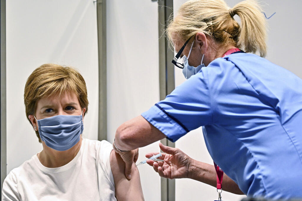 KK32 Glasgow - Škótska premiérka Nicola Sturgeonová dostáva druhú dávku vakcíny proti ochoreniu Covid-19 od spoločnosti AstraZeneca počas očkovania 21. júna 2021 v Glasgowe. FOTO TASR/Ap
First Minister of Scotland Nicola Sturgeon receives her second dose of the AstraZeneca Covid-19 vaccine, administered by staff nurse Susan Inglis, at the NHS Louisa Jordan vaccine centre in Glasgow, Scotland, Monday June 21, 2021. (Jeff J Mitchell/Pool via AP)