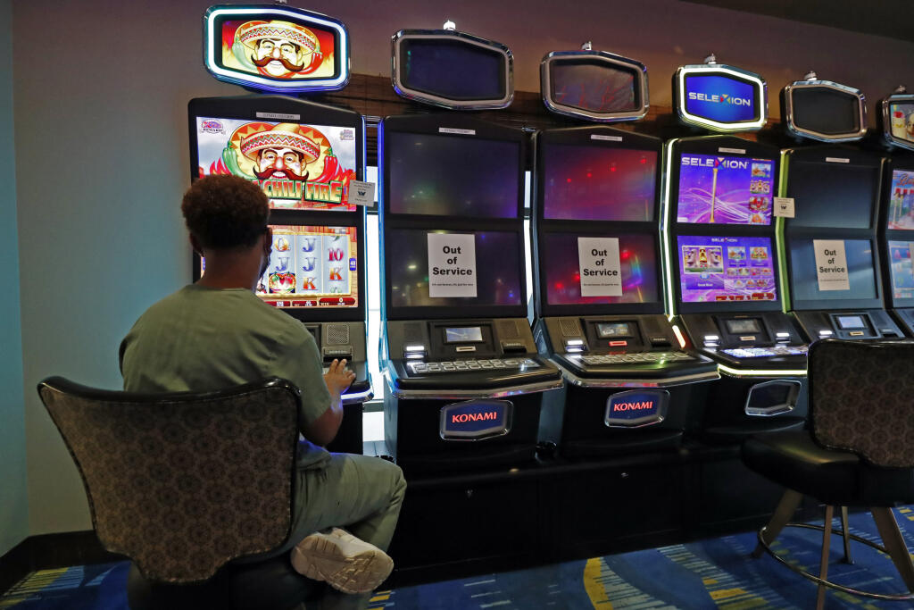 KK21 Vicksvurg - Muž sa hrá videohru počas znovuotvorenia kasína v americkom Vicksvurgu 21. mája 2020. FOTO TASR/AP
A patron plays at a video slot machine next to ones that are placed out of service by the Vicksburg, Miss., WaterView Casino and Hotel management, so as to allow players at other machines proper social distancing, Thursday, May 21, 2020. Gaming statewide was shutdown for two-month due to coronavirus, and the casinos were allowed to reopen Thursday, amid enhanced restrictions to kee