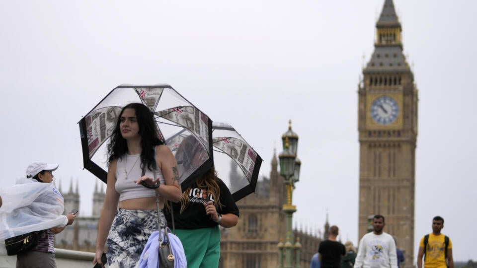 PK 19 Londýn - Ľudia s dáždnikmi kráčajú pri veži Big Ben za mierneho dažďa v Londýne 16. augusta 2022. Jedná sa o prvý dážď po dlhom období sucha. Britská meteorologická služba vydala žltú výstrahu pred búrkami pre Anglicko a Wales. Búrky môžu spôsobiť záplavy, výpadky elektriny a obmedziť dopravu. FOTO TASR/AP
Tourists use umbrellas as light rain started in London, Tuesday, Aug. 16, 2022. The first rain has arrived in London after a long very dry period. The Met Office has issued a yellow thu