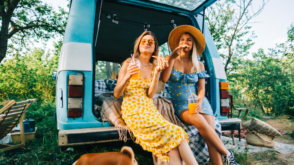 Two,Attractive,Cheerful,Women,Drinking,Lemonade,Near,Van,And,Eating