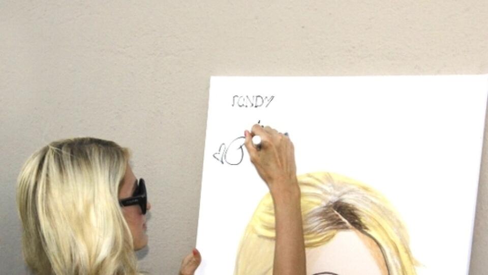 Paris Hilton podpisuje svoj portrét.