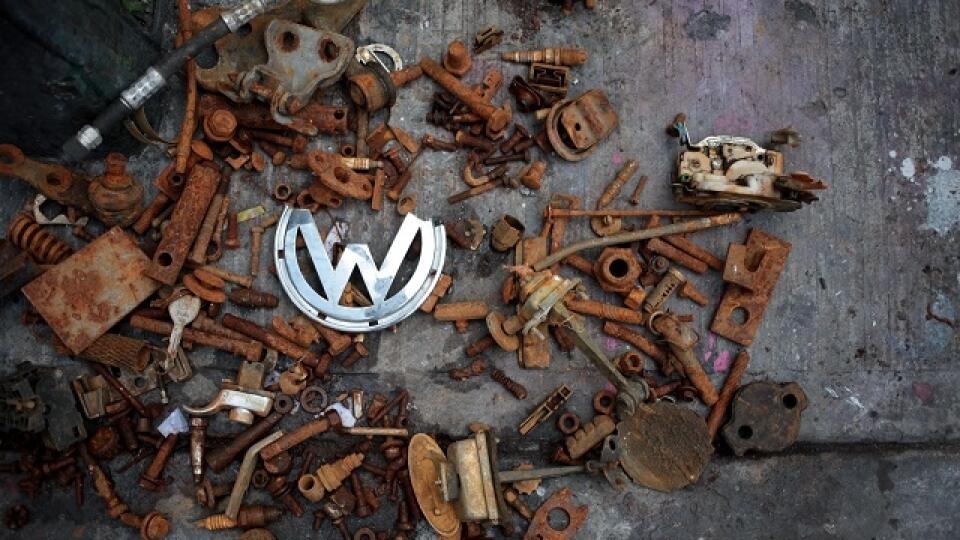 In this Tuesday, July 21, 2015 photo, a broken Volkswagen logo lies among other rusted car parts at the scene where Armando Garcia and his father, Armando Aguilar, remodel Volkswagen beetles in Mexico City. The last Volkswagen beetle came off the Mexican production line in 2003. (AP Photo/Sofia Jaramillo)