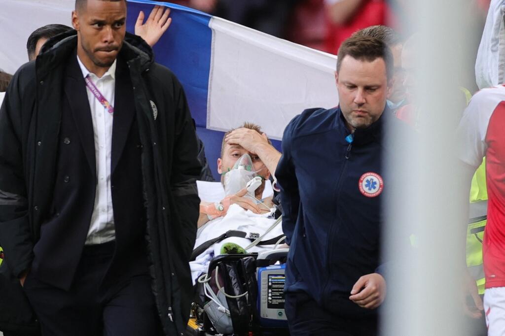 Dánskeho futbalistu Eriksena odvážajú pri vedomí z hracej plochy.