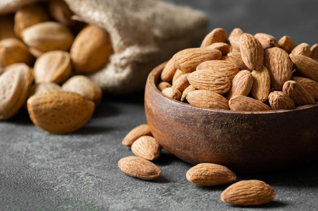Delicious,Sweet,Almonds,In,Wooden,Bowl,On,Rustic,Background,,Roasted