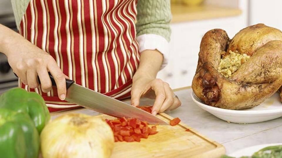 mid section view of a woman chopping tomatoes