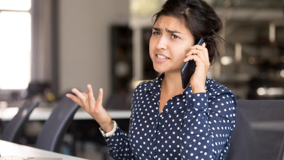 Outraged,Attractive,Indian,Female,Employee,Talking,By,Phone,,Arguing,With