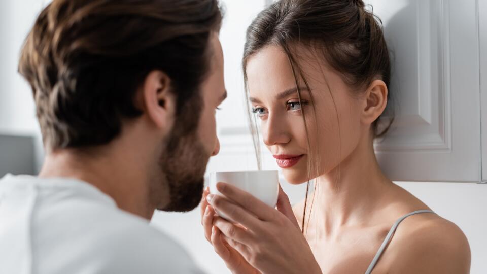 Young,Woman,In,Bra,Holding,Cup,And,Looking,At,Blurred