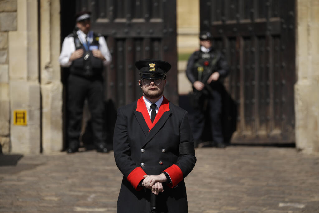JB 47 Windsor - Člen kráľovskej stráže stojí s policajtmi pred Bránou kráľa Henryho VIII. Windsorského zámku vo Windsore 17. apríla 2021 pred pohrebom britského princa Philipa, manžela britskej kráľovnej Alžbety II., ktorý zomrel minulý piatok vo veku 99 rokov. Pohreb sa uskutoční v sobotu popoludní v areáli Windsorského zámku, informovala v pondelok stanica BBC. Pohrebné obrady sa budú konať v tamojšej kaplnke svätého Juraja o 15.00 h miestneho času (16.00 h SELČ). Celý obrad sa uskutoční výl