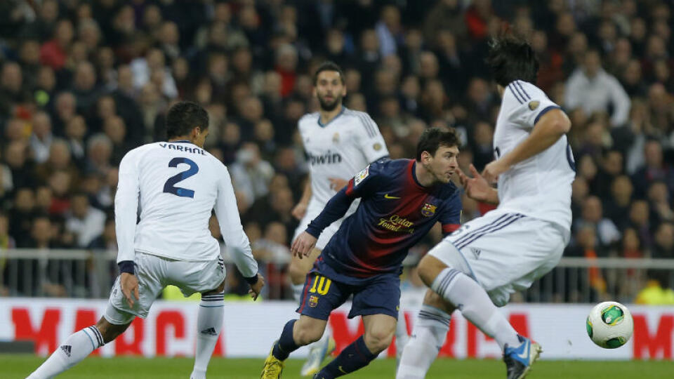 Hráč FC Barcelona Lionel Messi (druhý sprava) v súboji o loptu s hráčom Realu Madrid Raphaelom Varaneom.