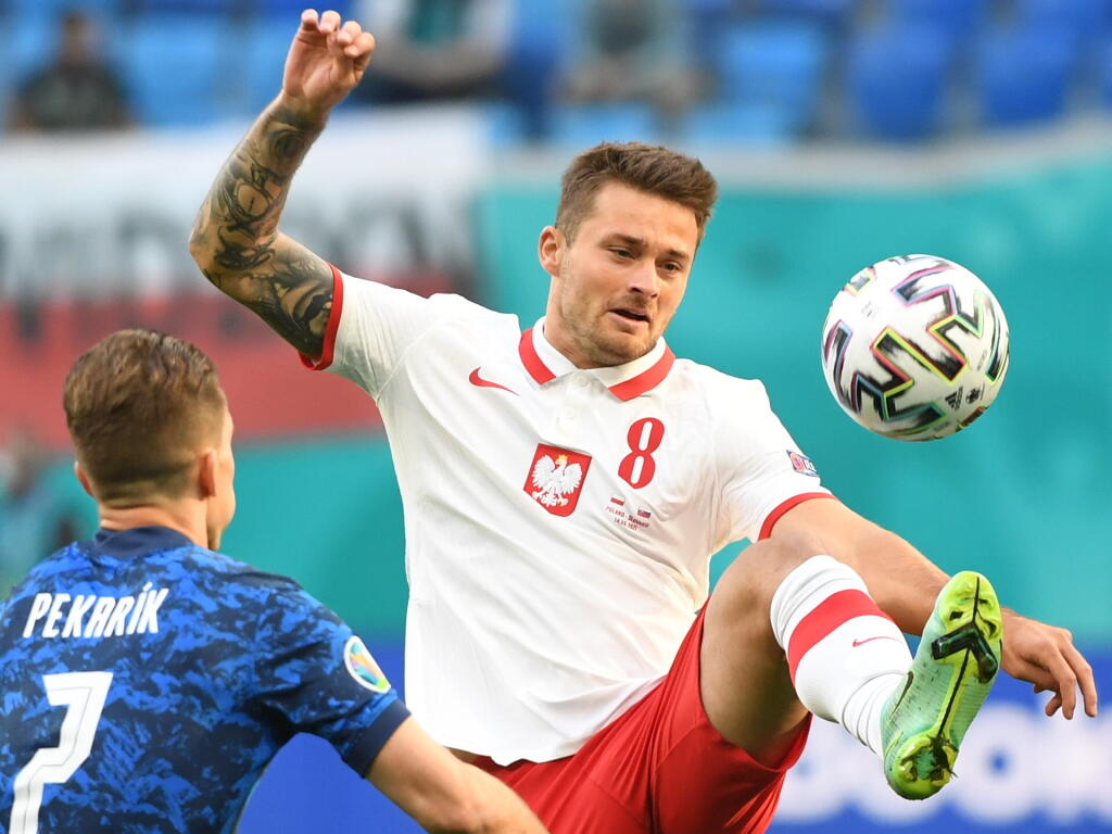 Na snímke vľavo slovenský hráč Peter Pekarík a vpravo poľský hráč Karol Linetty v zápase E-skupiny na majstrovstvách Európy vo futbale Poľsko - Slovensko 14. júna 2021 v ruskom Petrohrade. FOTO TASR - Martin Baumann