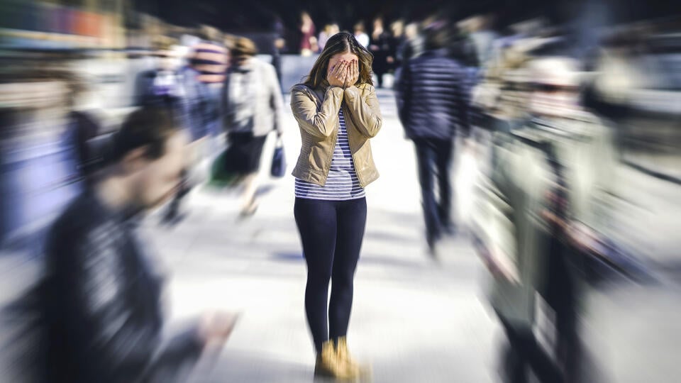 Panic attack in public place. Woman having panic disorder in city. Psychology, solitude, fear or mental health problems concept. Depressed sad person surrounded by people walking in busy street.