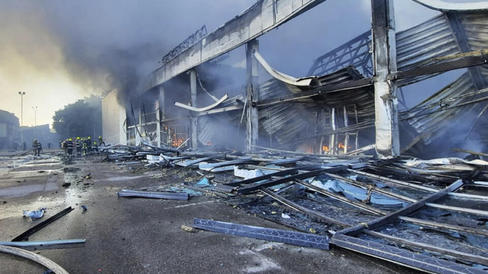 Na snímke z videozáznamu hasiči pracujú na hasení požiaru v obchodnom centre, ktoré vyhorelo po raketovom útoku v Kremenčuku na Ukrajine v pondelok 27. júna 2022.