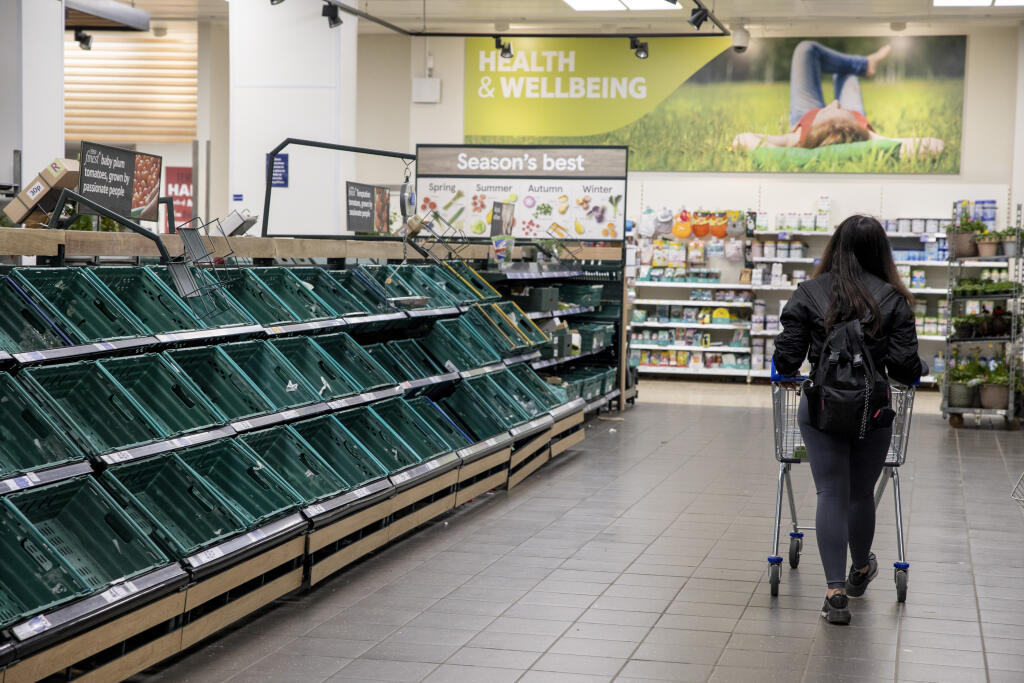 A customer seen with a trolley walking along the aisle of