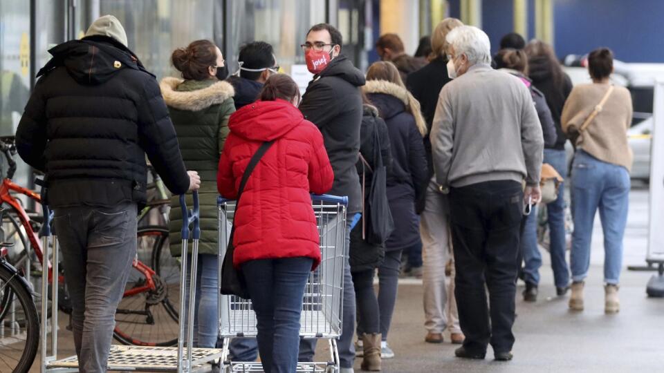 JB 27 Viedeň - Ľudia s ochrannými rúškami čakajú v rade pred obchodom po ich znovuotvorení v rámci uvoľnenia opatrení po lockdowne vo Viedni 7. decembra 2020. Od pondelka sú v Rakúsku po skončení trojtýždňového lockdownu opäť otvorené obchody, nákupné centrá, kaderníctva, kozmetické a masážne salóny. Na jedného zákazníka pritom pripadá desať štvorcových metrov a povinné je taktiež nosenie rúšok. FOTO TASR/AP
People line up in front of a shop after the stores reopen after a lock down in Vienna,