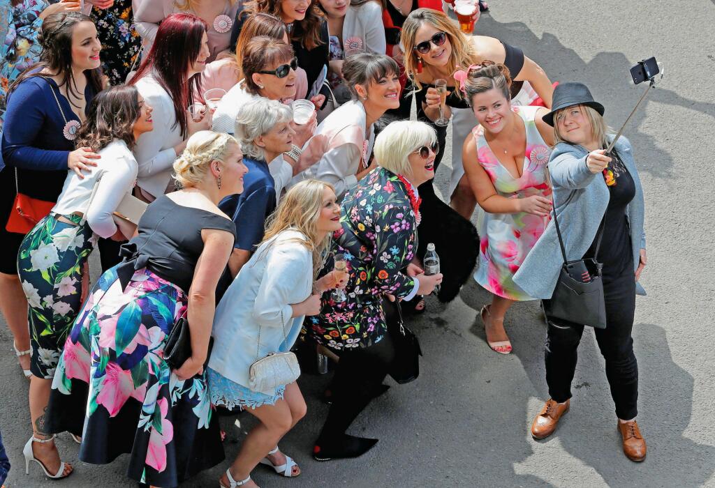 Racegoers pose for a selfie photograph during the final day of the Grand National Festival horse race meeting at Aintree Racecourse in Liverpool, northern England on April 14, 2018., Image: 368516450, License: Rights-managed, Restrictions: , Model Release: no, Credit line: Profimedia, AFP