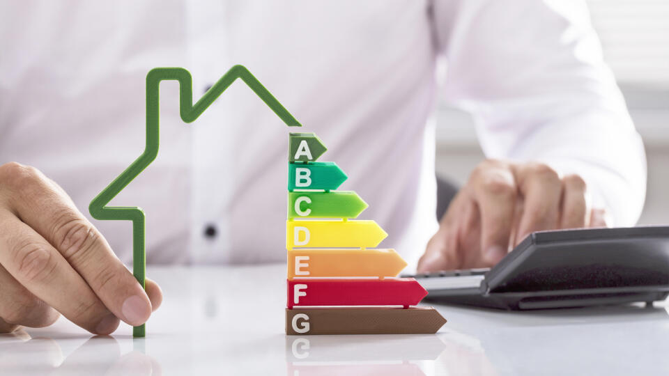 Close-up,Of,A,Businessman,Using,Calculator,Holding,Outline,Of,House