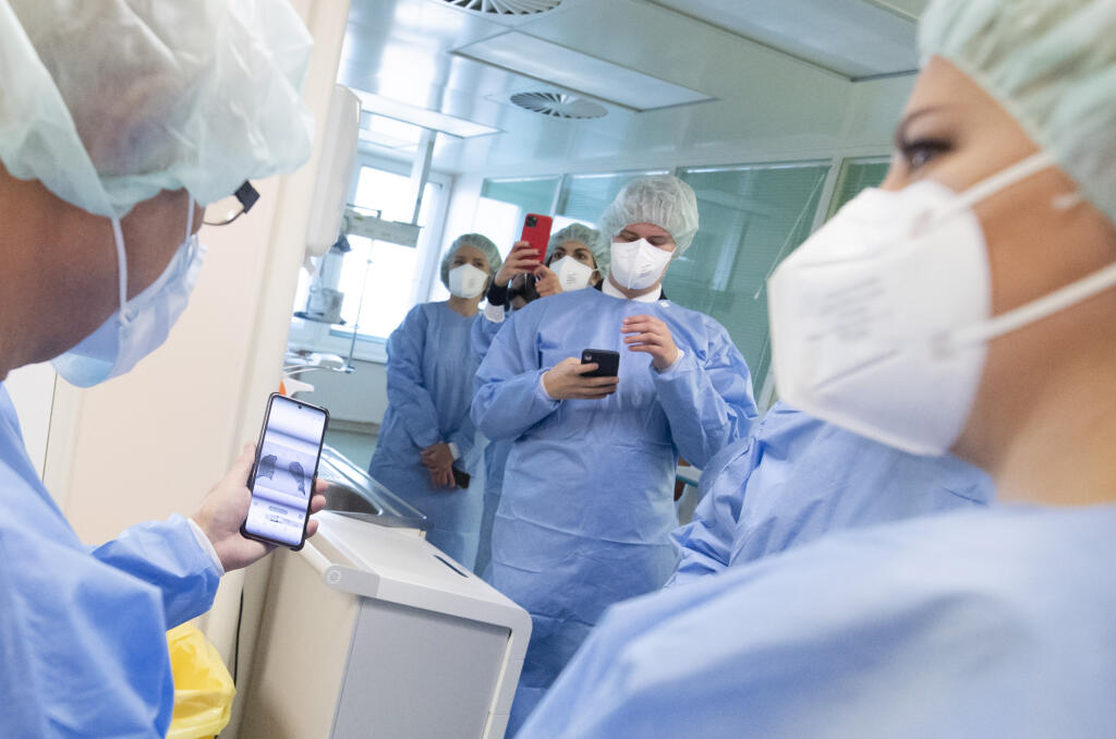 Na snímke lekár ukazuje na mobile RTG pľúc pacienta s covidom, vpravo prezidentka SR Zuzana Čaputová počas návštevy Nemocnice Ružinov, kde sa boli pozrieť na Oddelenie intenzívnej medicíny, 23. novembra 2021 v Bratislave. FOTO TASR - Martin Baumann