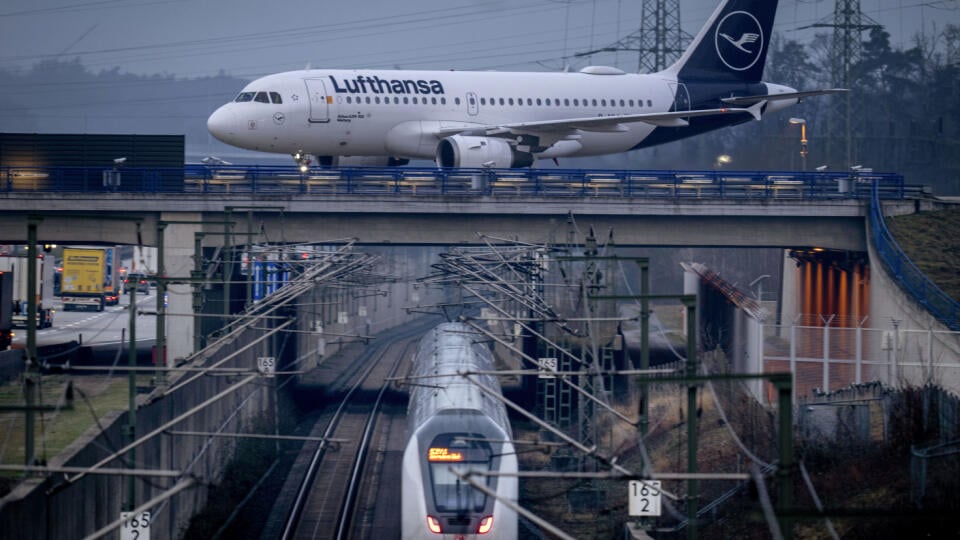 Lietadlo Lufthansy stojí nad železničnou traťou vo Frankfurte nad Mohanom.