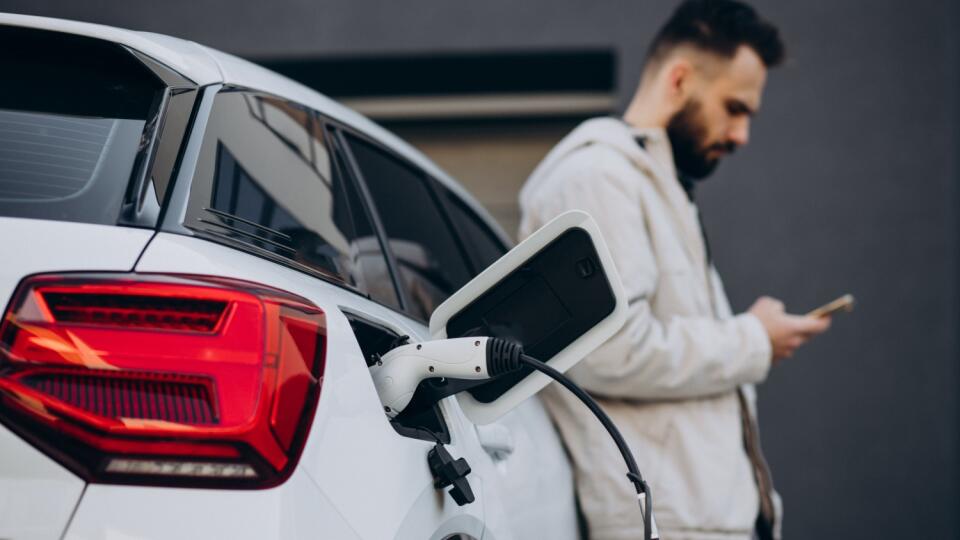 Man,Charging,Electric,Car,By,The,House