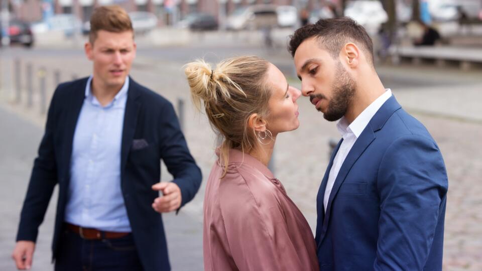 woman kissing man while another is upset