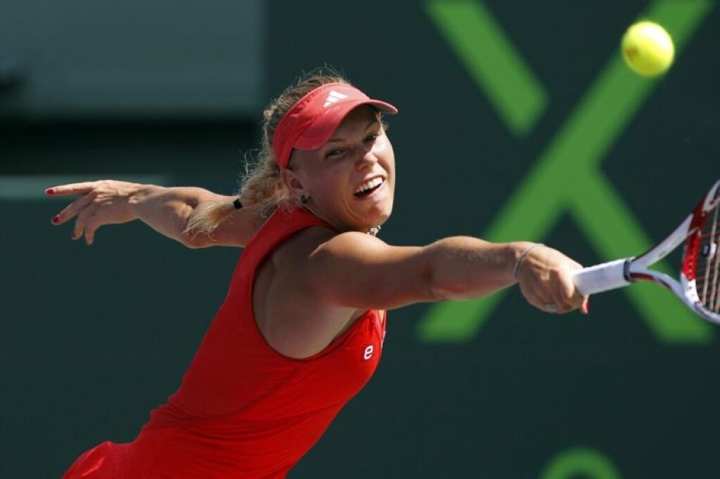Caroline Wozniacki, of Denmark, returns the ball to Maria Sharapova, of Russia, during the Sony Ericsson tennis tournament, Thursday, March 29, 2012, in Key Biscayne, Fla. Sharapova won the match 4-6, 6-2, 6-4. (AP Photo/Lynne Sladky)