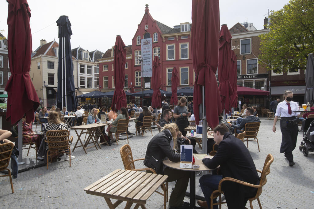KK24 Urtrecht - Ľudia sedia počas otvorenia terás  28. apríla 2021 v holandskom Ultrechte. Holandsko v stredu po štyroch mesiacoch tvrdého lockdownu súvisiaceho s pandémiou nového typu koronavírusu otvorilo aj napriek stále vysokému počtu nakazených obchody a terasy reštaurácií a ruší i zákaz nočného vychádzania. FOTO TASR/AP
Dutch customers eager for their first drink of coffee or something stronger at a cafe terrace have flocked to outdoor seating as the Netherlands' lockdown eased in Utrecht,