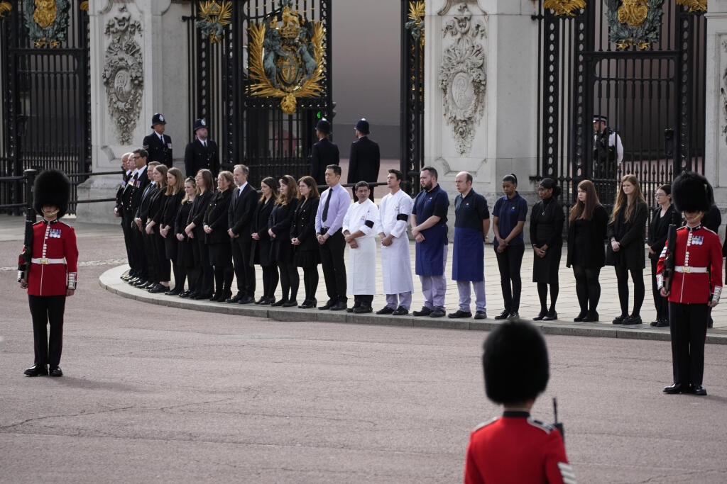 Zamestnanci Buckinghamského paláca stoja pred vstupom do paláca počas štátneho pohrebu britskej kráľovnej Alžbety II.