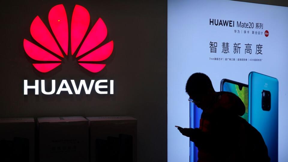 Na archívnej snímke z 11. decembra 2018 muž si pozerá smartfón pred obchodom Huawei v Pekingu. Čínsky telekomunikačný koncern Huawei dokázal, aj napriek tlaku USA, v tomto roku zvýšiť tržby približne o 18 %. Tempo rastu tržieb sa však spomalilo, keď vlani stúpli o 19,5 %. FOTO TASR/AP