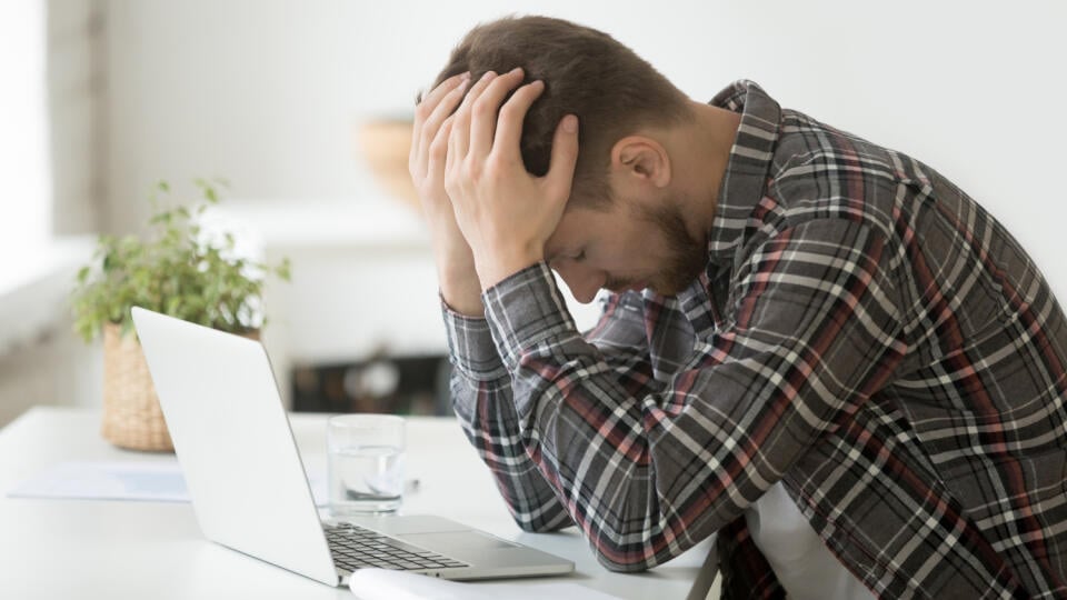 Frustrated,Depressed,Man,Holding,Head,In,Hands,Shocked,By,Bankruptcy