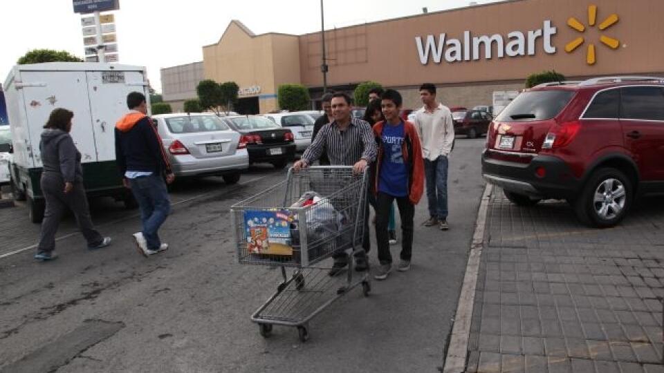 In this Thursday, Dec. 26, 2013 photo, a family leaves a local Walmart in Mexico City. Looking around a Mexico dotted by Starbucks, Wal-Marts and Krispy Kreme outlets, it's hard to remember the country before the North American Free Trade Agreement, which has dramatically expanded consumer choice and trade since it took effect 20 years ago.(AP Photo/Marco Ugarte)