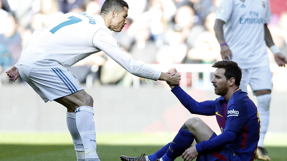 Real Madrid's Cristiano Ronaldo, left, helps Barcelona's Lionel Messi get back on his feet during the Spanish La Liga soccer match between Real Madrid and Barcelona at the Santiago Bernabeu stadium in Madrid, Spain, Saturday, Dec. 23, 2017. (AP Photo/Francisco Seco)